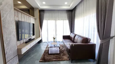 Luxurious living room with modern decor, large windows, and elegant furniture.