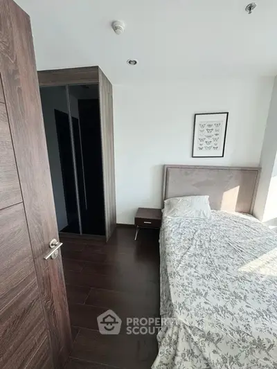 Cozy bedroom with modern decor and natural light, featuring a stylish bed and wooden flooring.