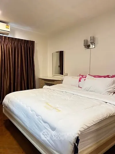 Cozy bedroom with elegant decor and plush bedding in a modern apartment.