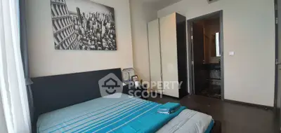 Modern bedroom with cityscape artwork and ensuite bathroom in stylish apartment.