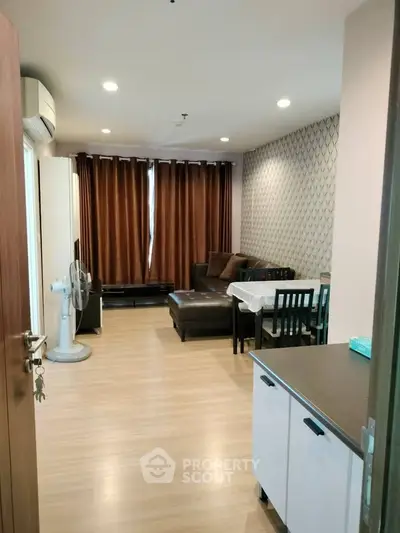 Modern living room with stylish decor and ample natural light, featuring a cozy seating area and dining space.