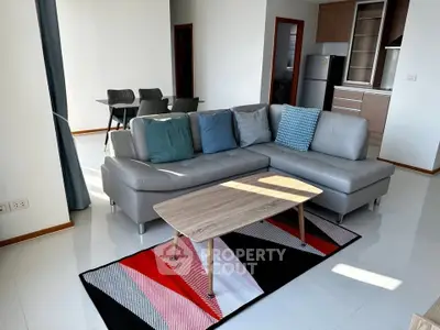 Modern living room with stylish furniture and open kitchen layout in a bright apartment.