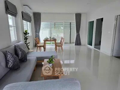 Spacious modern living room with elegant dining area and large windows