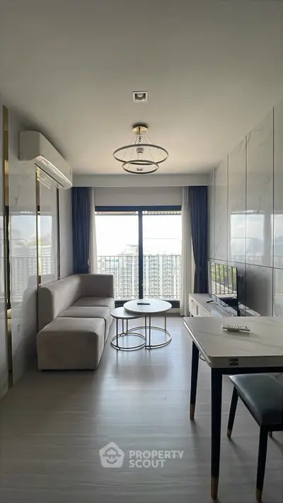 Modern living room with sleek design and city view, featuring a cozy sofa and stylish decor.