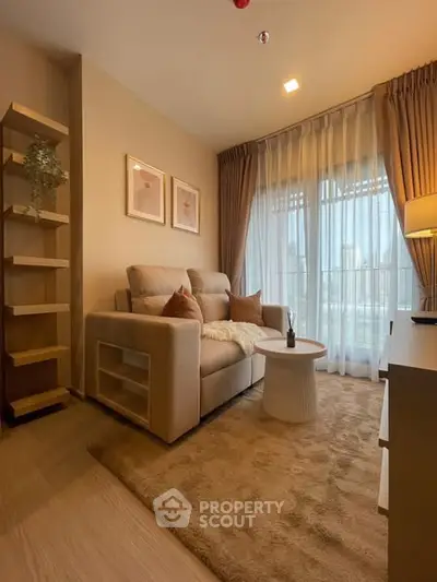 Cozy living room with plush sofa, elegant decor, and large window for natural light.