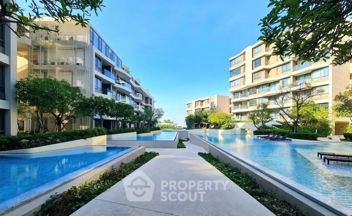 Luxurious modern apartment complex with stunning pool and lush greenery