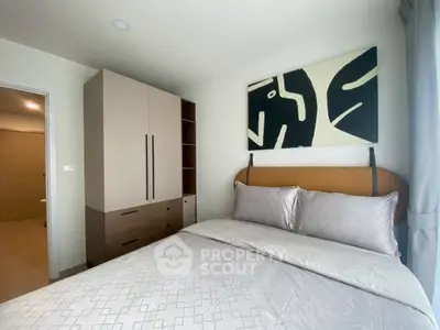 Modern bedroom with stylish decor and ample storage in a cozy apartment.