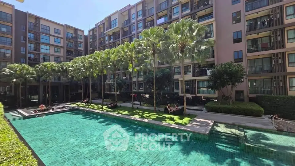 Luxurious apartment complex with stunning pool and lush palm trees, perfect for resort-style living.