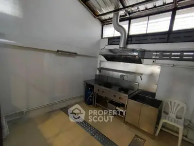 Spacious commercial kitchen with industrial-grade appliances and ample ventilation, ideal for a bustling restaurant or catering business.