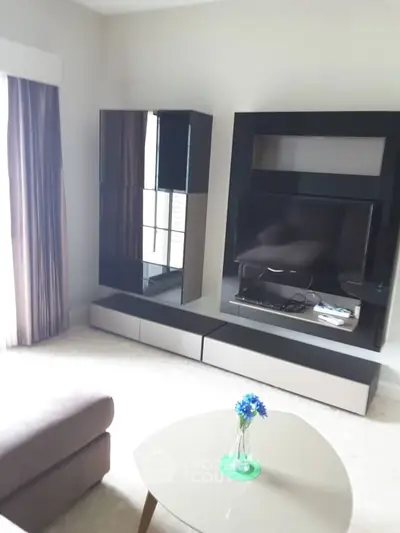 Modern living room with sleek TV unit and cozy sofa, perfect for relaxation.