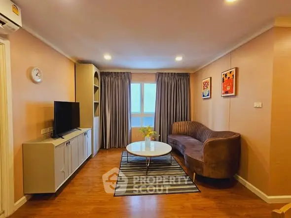 Charming living room with cozy sofa, modern TV setup, and elegant decor in a warm ambiance.