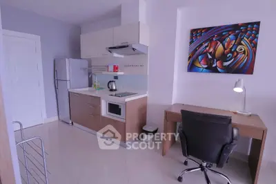 Modern kitchen with sleek appliances and stylish workspace in compact apartment.