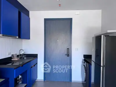 Modern kitchen with blue cabinetry, sleek appliances, and stylish design.
