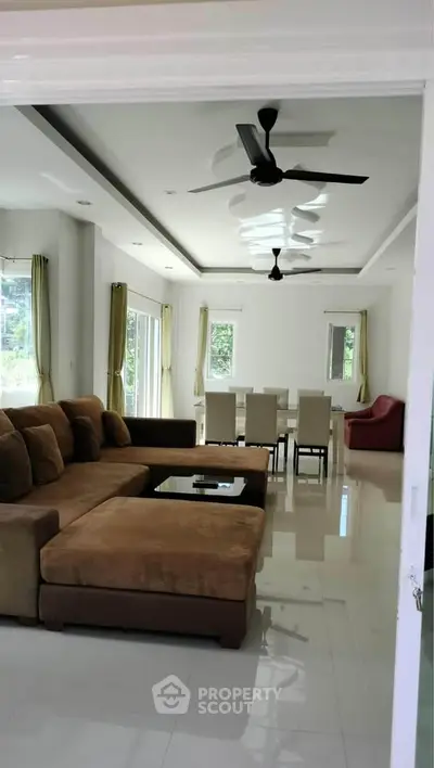 Spacious living room with modern furniture and large windows offering natural light.