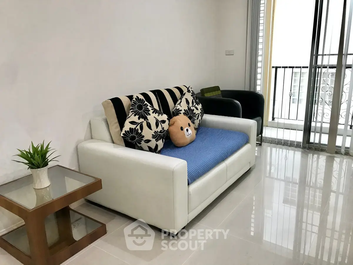 Modern living room with stylish sofa and balcony view, perfect for urban living.