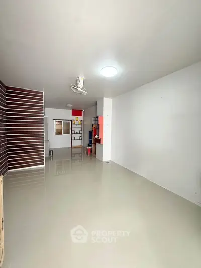 Spacious empty room with glossy tiled floor and modern ceiling light, perfect for customization.