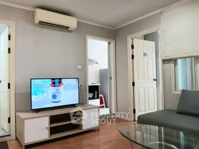 Modern living room with TV, air conditioning, and stylish decor in a cozy apartment.