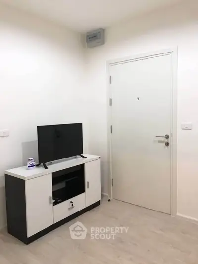 Modern minimalist living room with sleek TV stand and white door