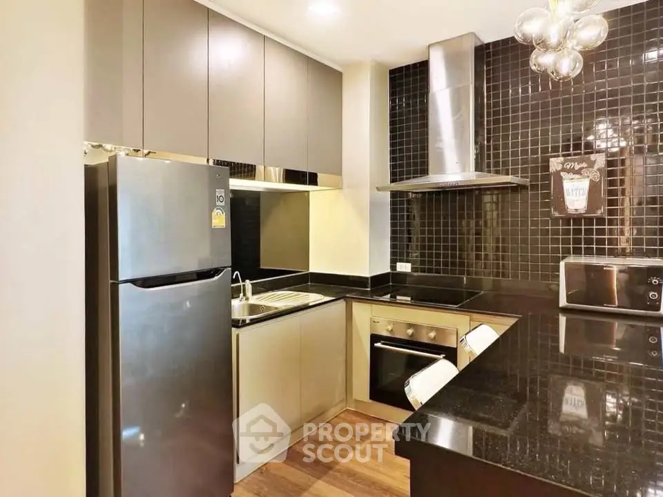 Modern kitchen with sleek black backsplash and stainless steel appliances