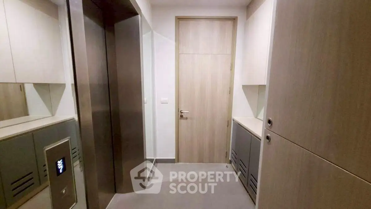 Modern apartment elevator lobby with sleek design and wooden accents.
