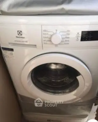 Modern washing machine in compact laundry space, ideal for efficient apartment living.