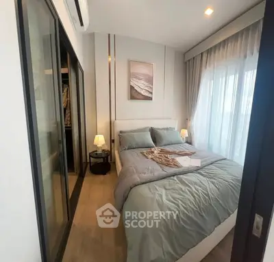 Modern bedroom with stylish decor and large window for natural light.