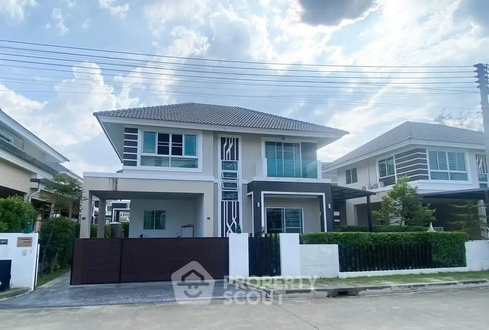 Modern two-story house with sleek design and spacious driveway in a serene neighborhood.