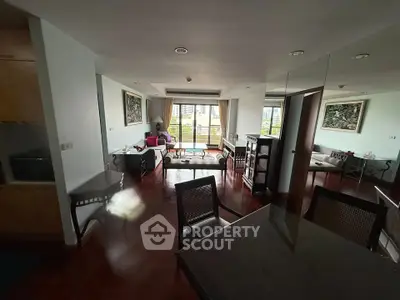 Spacious living room with elegant decor and large windows offering a stunning city view.
