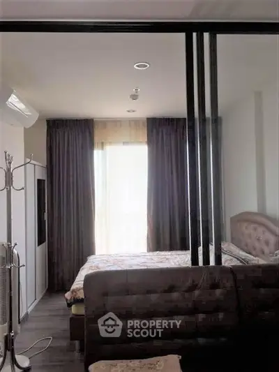 Cozy bedroom with modern decor and large window for natural light