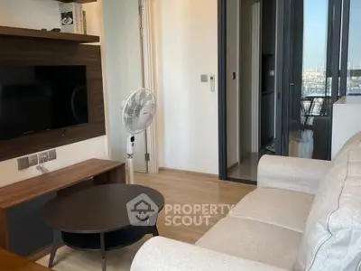 Modern living room with sleek furniture and city view balcony.