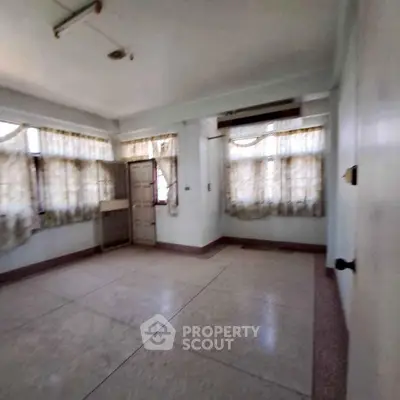 Spacious empty room with large windows and natural light, ideal for customization.