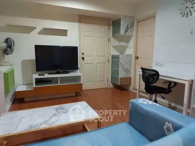 Modern living room with stylish furniture and entertainment setup in cozy apartment.