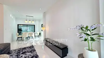 Elegant modern living room with dining area, featuring sleek furniture and stylish lighting.