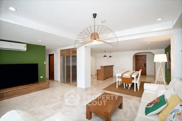 Spacious modern living room with open dining area, stylish lighting, and elegant decor.