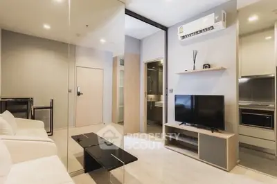 Modern living room with sleek furniture and built-in appliances in a stylish apartment.