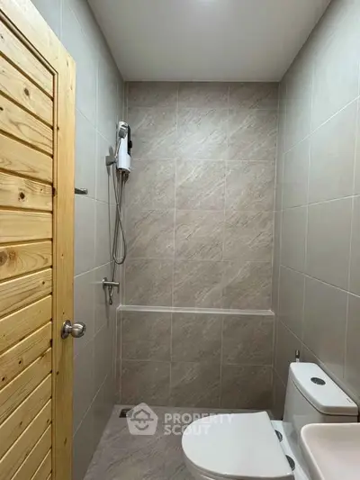 Modern minimalist bathroom with sleek tiles and wooden door
