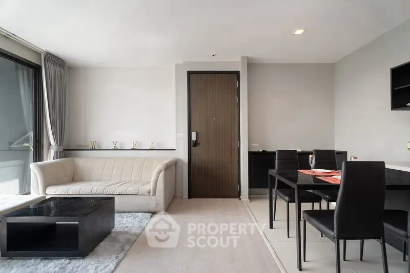 Modern living room with sleek furniture and dining area in a stylish apartment.