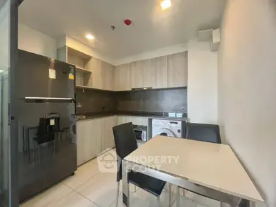Modern kitchen with sleek appliances and dining area in a stylish apartment.
