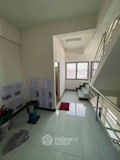 Spacious stairway area with tiled flooring and natural light, ideal for modern living.