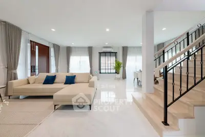 Spacious modern living room with elegant staircase and natural light