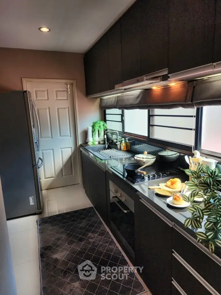 Modern kitchen with sleek black cabinets and stainless steel appliances