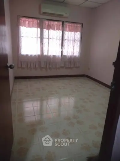 Cozy empty room with tiled floor and air conditioning, perfect for customization.