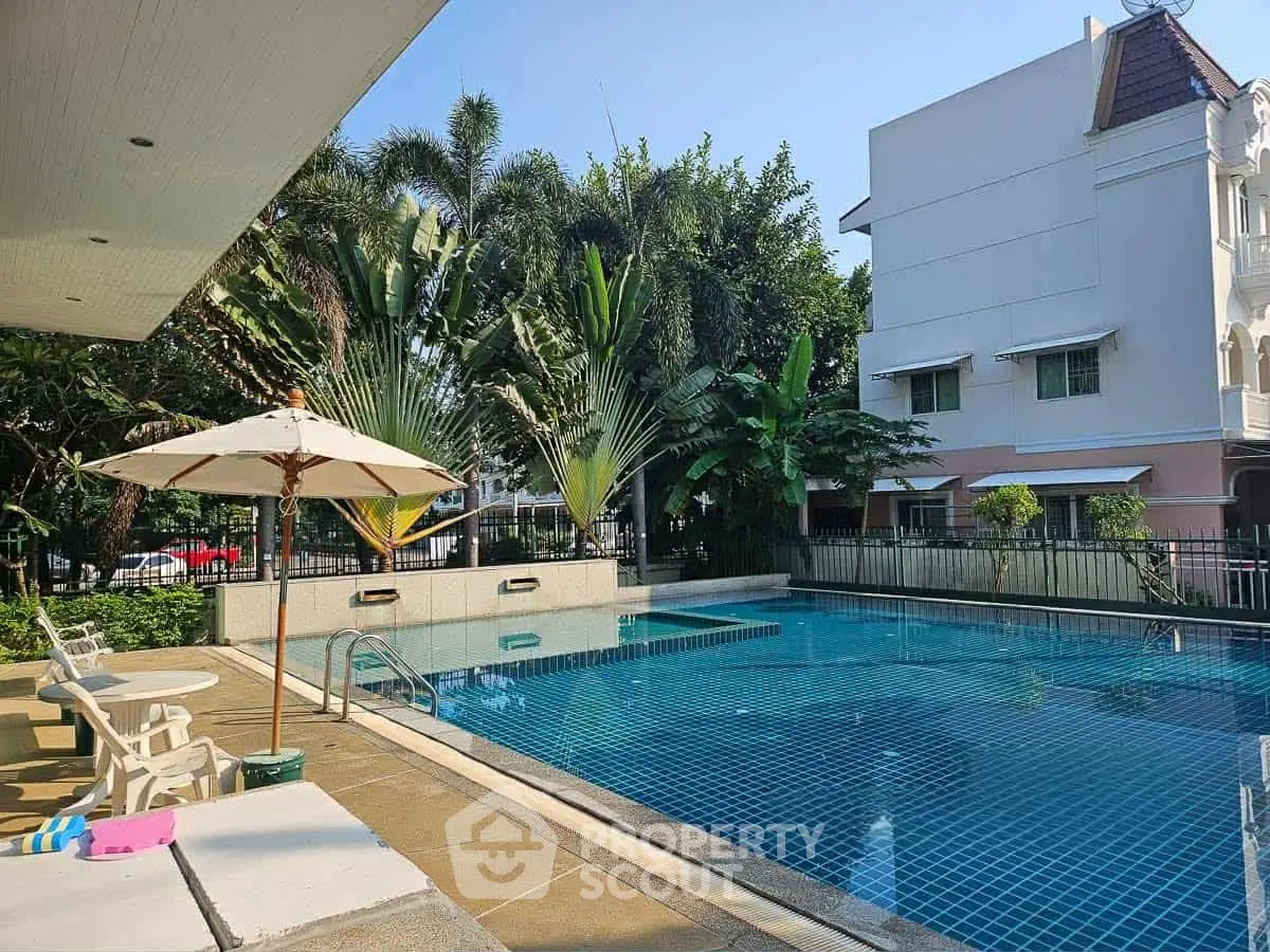 Luxurious residential pool area with lush greenery and modern design, perfect for relaxation and leisure.
