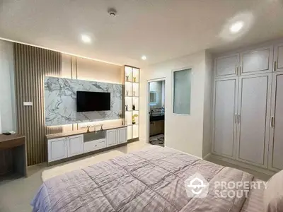 Luxurious modern bedroom with built-in TV and elegant storage solutions