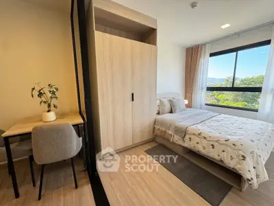 Modern bedroom with large window and cozy decor, featuring a study desk and wardrobe.