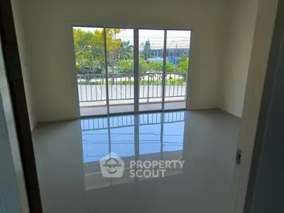 Spacious empty room with large windows and balcony view, perfect for customization.