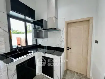 Modern kitchen with sleek black countertops and marble backsplash