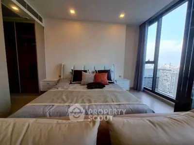 Luxurious bedroom with stunning city view and modern decor in high-rise apartment.