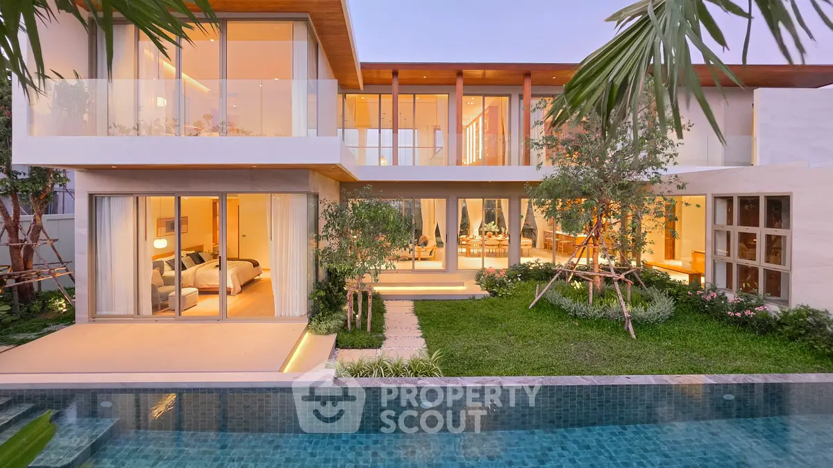 Luxurious modern villa with stunning pool and lush garden, featuring expansive glass windows and elegant design.
