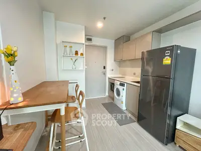Modern kitchen with sleek appliances and stylish dining area in a cozy apartment.